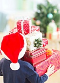 Boy (6-7) carrying christmas gifts