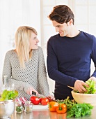 Paar bereitet Salat in der Küche zu