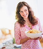 Woman carrying bowl with snacks