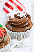 Schokoladencupcakes mit Zuckerblumen und Schneeflocken zu Weihnachten