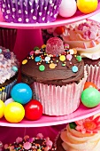 Colorful cupcakes and candies for a party on a cake stand