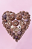 Herz aus Schokopralinen, Schokoladengebäck und Schokoladenrolle