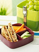 Sandwiches mit Thunfisch, Tomaten und Chorizo, Gemüse und Trauben in Lunchbox