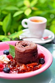 Chocolate souffle with summer berry sauce