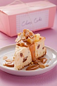 A piece of cheesecake with caramel sauce and sliced almonds