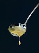 Vanilla sauce dripping from a ladle