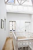 Gallery landing with artistically crafted balustrade lit from above by skylight