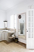 Orientalisches Bad mit gefliestem Waschtisch; gemauerte Dusche und marokkanische Hängelampe im Spiegelbild