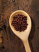Chocolate pearls in a wooden spoon