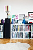 Record collection on shelves against wall & candelabra on speaker