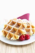 Waffles with icing sugar and raspberries