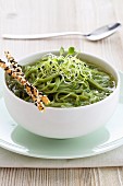 Green spaghetti in vegetable stock with grissini