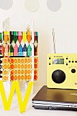 Laptop, radio and colourful arrangement on white desk