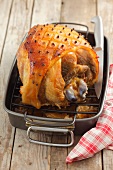 Roasted ham with bone in a roasting dish