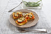 Polenta squares with zucchini, beans, tomatoes and carrots