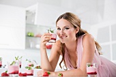 Junge Frau hält ein Glas Joghurt mit Beeren