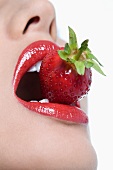 Young woman holding strawberry, close up