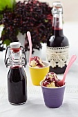 Ice cream in cups with elderberry syrup in bottles