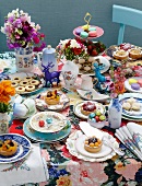 A plentiful array of cakes with a colourful display of flowers