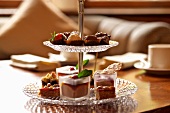 Tiered cake stand holding filled chocolates and mini cakes