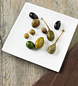 Verschiedene Oliven und Riesenkapern auf Platte
