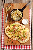 Tarte flambée with sour cream, cheese, onions and bacon