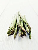 Green asparagus on a white wooden surface
