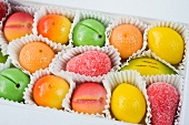 a box of coloured yellow, green, orange and red marzipan fruit sweets for Christmas
