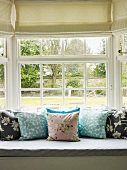 Cushions on window seat with view of garden