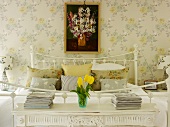 Romantic bedroom with bedside tables, floral wallpaper and picture of flowers