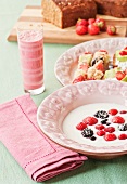 A Swedish breakfast of berries in sour milk, fruit and coconut skewers and raspberry and kiwi smoothies