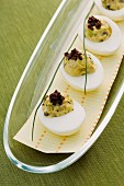 Russische Eier, garniert mit gehackten Oliven auf einer Platte