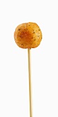 A skewer topped with a deep-fried cod dumpling