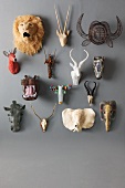 Miniature hunting trophies hanging on a grey wall