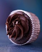 A chocolate cupcake with chocolate cream icing