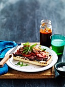 Steak sandwich with tomatoes, onions and barbecue sauce