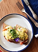 Toasted bread topped with a poached egg, salmon and hollandaise sauce