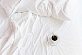A coffee cup in the bed