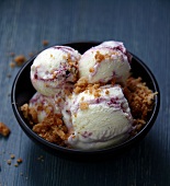 Several scoops of blackberry and blueberry ice cream sprinkled with crumble