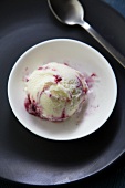 A scoop of blackberry and blueberry ice cream in a bowl