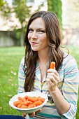 A young girl eating carrots