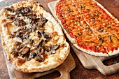 Pizza mit Pilzen und Pizza mit Tomaten und Käse auf Schneidebrettern