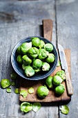 Brussels sprouts in a bowl on a chopping board