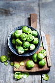 Rosenkohl in Schüssel auf Schneidebrett