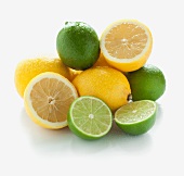 A pile of limes and lemons, whole and halved