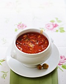 bowl of meat and tomato goulash soup with olives