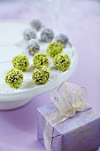 Chocolate truffles with coconut shawings on white plate and gift box