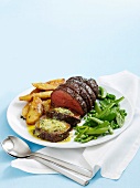 Fillet of beef with anchovy butter, roast potatoes and peas