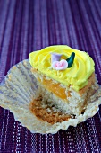 Half a cupcake topped with lemon icing