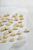 Lots of almonds scattered on a sheet of paper